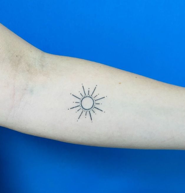 Imagen de un brazo con un tatuaje del sol
